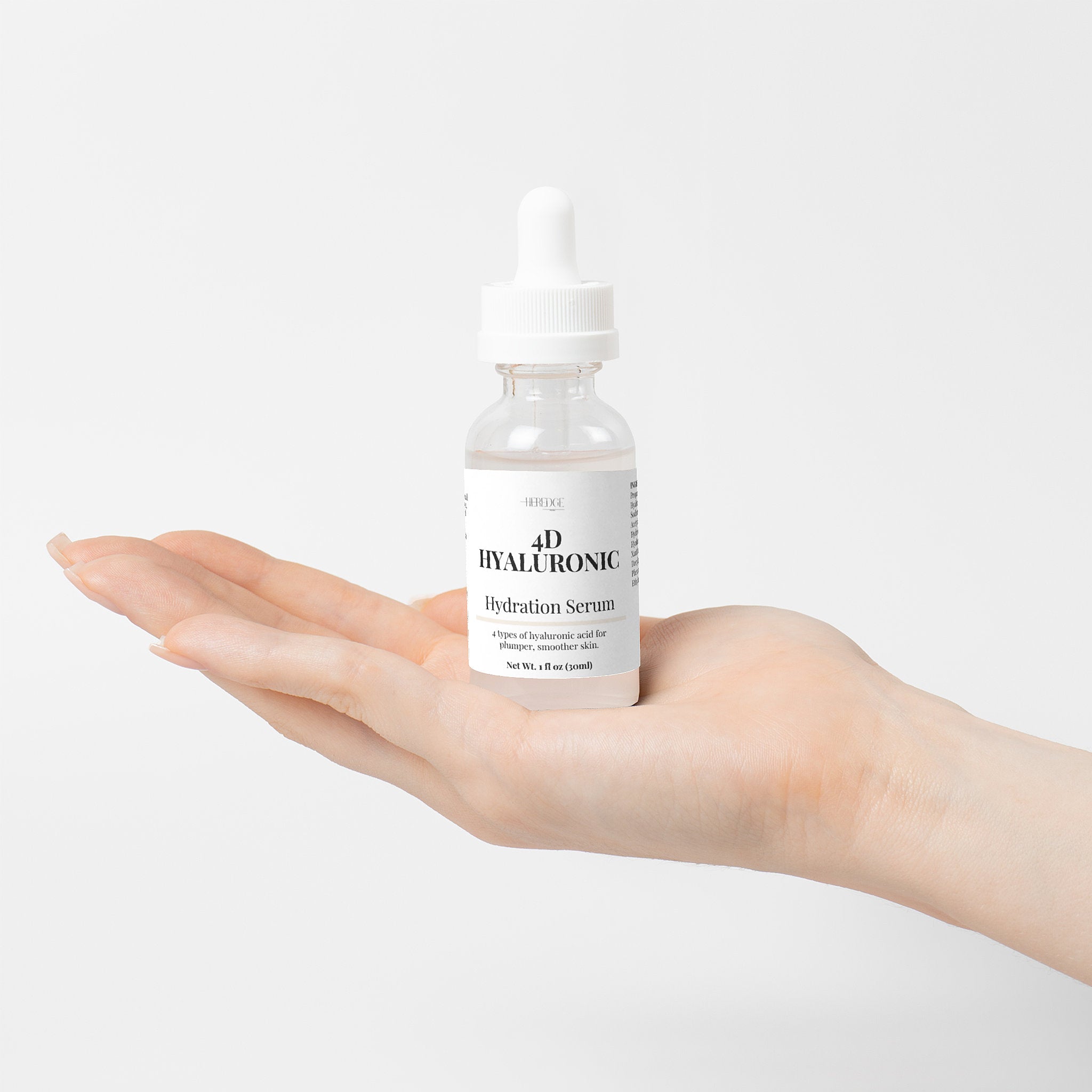 Bottle of 4D Hyaluronic Serum held in a hand against a white background
