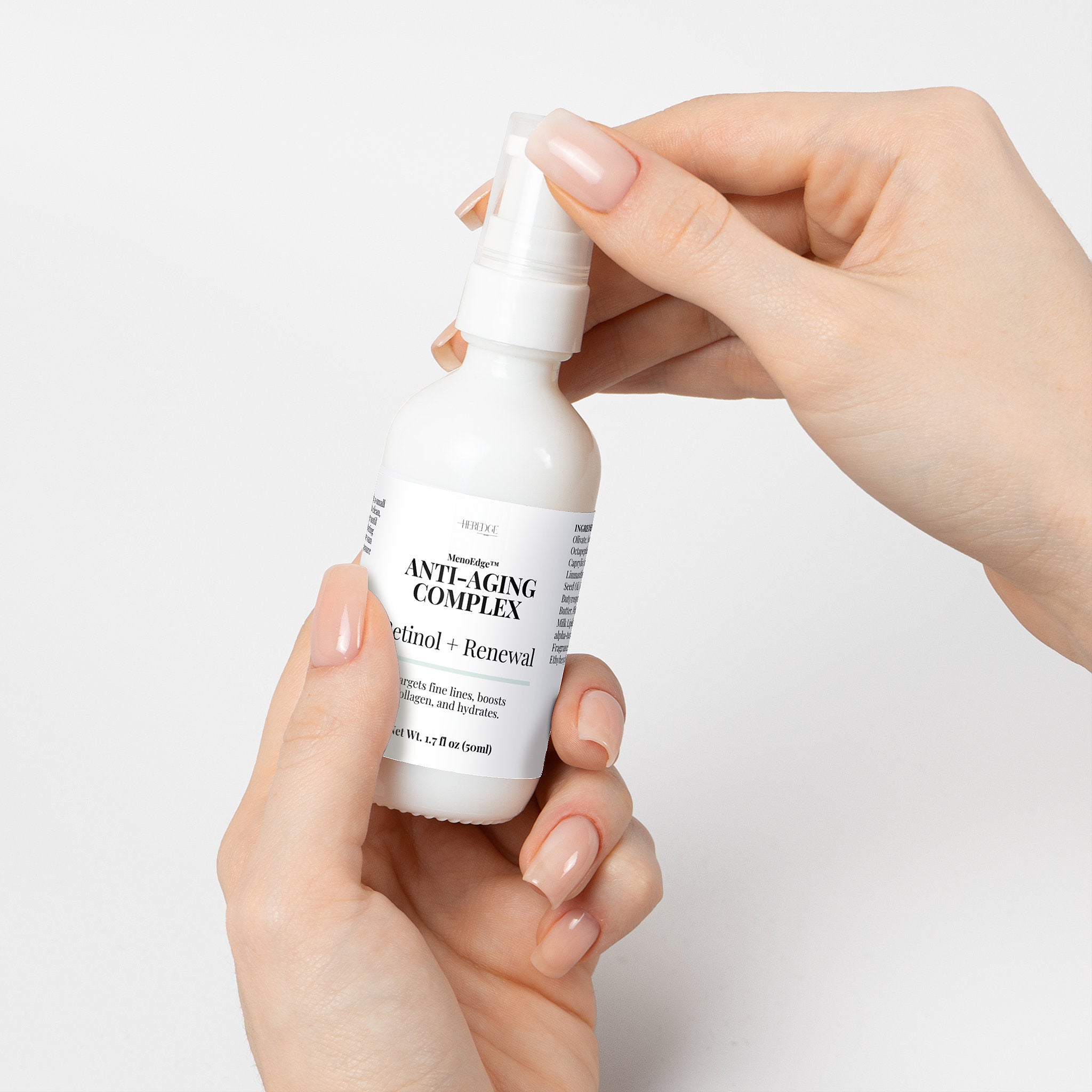 Hand holding a bottle of 'Anti-Aging Complex' against a light background